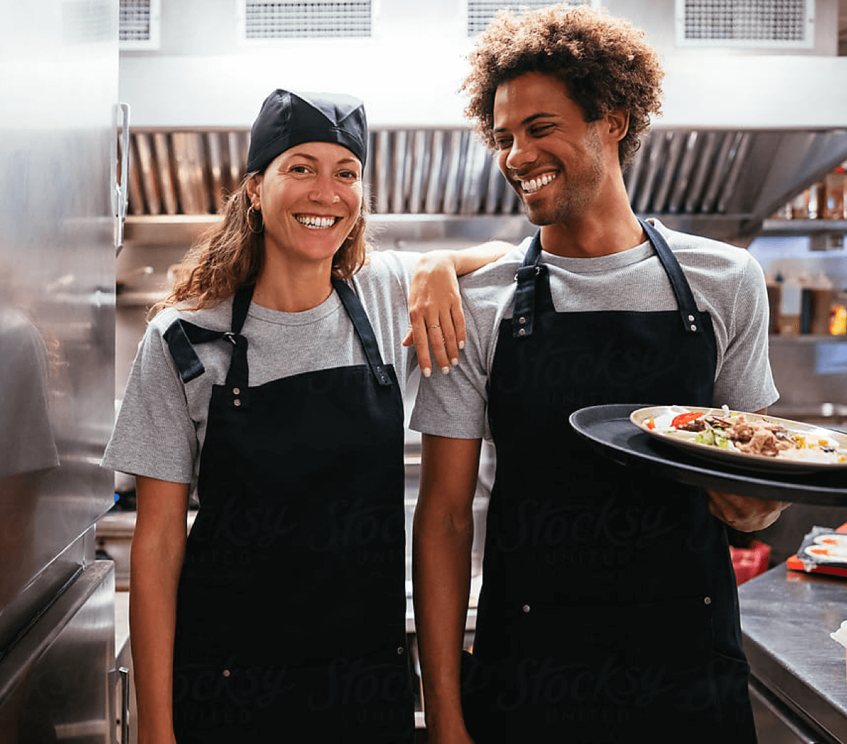 Two restaurant workers happily standing side by side