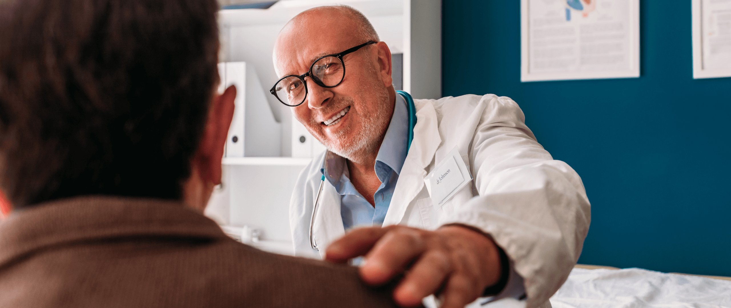 Portrait of physician with glasses and stethoscope around his neck examining senior patient